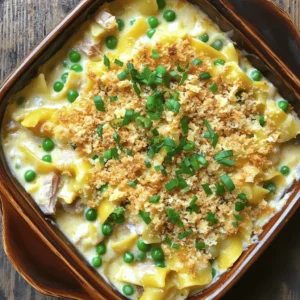 - 12 oz egg noodles - 2 cans (5 oz each) tuna in water, drained - 1 can (10.5 oz) cream of mushroom soup - 1 cup frozen peas - 1/2 cup mayonnaise - 1 cup shredded sharp cheddar cheese - 1/4 cup grated Parmesan cheese - 1/2 cup milk - 1/4 cup chopped green onions - 1 tsp garlic powder - Salt and pepper to taste - 1 cup breadcrumbs - 2 tbsp olive oil When I make a classic tuna noodle casserole, I rely on simple yet tasty ingredients. Each one adds a unique flavor and texture that makes this dish special. The egg noodles provide a soft base, while the tuna gives a nice protein boost. Cream of mushroom soup adds creaminess, and frozen peas add color and some sweetness. Mayonnaise is key for richness. The sharp cheddar cheese brings a robust flavor, and Parmesan gives a nice salty touch. The milk helps to bind everything together, while green onions add a fresh crunch. Garlic powder adds depth, and salt and pepper enhance all the flavors. The breadcrumbs create a golden, crunchy topping that contrasts nicely with the creamy filling. You can even mix it up with different cheeses or fresh herbs. This flexibility lets you create your own version of this comforting dish. Check out the Full Recipe for more details on how to put it all together! - Preheat the oven to 350°F (175°C). - Cook the egg noodles according to package directions. This usually takes about 7-10 minutes. Drain them after cooking. - In a large mixing bowl, combine all main ingredients. - Add the drained tuna, cream of mushroom soup, frozen peas, mayonnaise, cheese, milk, green onions, garlic powder, salt, and pepper. - Mix until well blended. Make sure everything is combined evenly. - Gently fold in the cooked noodles. - Transfer this mixture to a greased casserole dish. Spread it out evenly. - For the topping, mix breadcrumbs with olive oil in a small bowl. - Sprinkle this topping over the casserole. - Bake for 25-30 minutes. The top should turn golden brown and look crisp. - Let it cool for about 5 minutes before serving. For the full recipe, check the details above. To get the best texture, bake your tuna noodle casserole for 25 to 30 minutes. This time allows the flavors to meld and the top to become golden. I recommend checking for doneness by inserting a knife into the center. If it comes out hot, your dish is ready. You can make this dish dairy-free by using almond milk and a dairy-free cream soup. For those who prefer a different protein, canned chicken works well in place of tuna. This swap still gives you that hearty feel while adding a new flavor twist. Pair your cozy casserole with a fresh side salad. A simple green salad with a light vinaigrette complements the rich flavors. Other great sides include steamed broccoli or a light coleslaw. These add crunch and balance to your meal. Explore the [Full Recipe] for more details on how to prepare this classic dish! {{image_2}} You can make this dish lighter. One way is to use whole wheat noodles. They add fiber and nutrients. Whole wheat noodles also have a nice texture. Another great swap is yogurt instead of mayonnaise. Greek yogurt adds creaminess without the extra fat. Plus, it brings a bit of tang to the dish. These small changes help you enjoy comfort food while keeping it healthy. To boost the taste, you can add spices. Paprika brings a smoky flavor. Cayenne adds a little heat. Just a pinch can transform your casserole into a flavor-packed meal. You can also mix in vegetables. Bell peppers add crunch and sweetness. Mushrooms give a rich, earthy taste. Adding veggies not only enhances flavor but also packs in more nutrients. You can even use leftover veggies you have at home. This makes the dish even more versatile and fun. For the full recipe, check out the details above! To keep your tuna noodle casserole fresh, follow these tips: - Refrigeration: Place leftovers in an airtight container. Store in the fridge for up to 3 days. Make sure to cool it down before sealing. - Freezing: For longer storage, you can freeze the casserole. Use a freezer-safe container. It will keep well for about 3 months. Label the container with the date to help you remember. When it's time to enjoy your casserole again, proper reheating is key: - Oven Method: Preheat your oven to 350°F (175°C). Place the casserole in a baking dish. Cover it with foil to retain moisture. Heat for about 20-25 minutes. - Microwave Method: If you're short on time, use the microwave. Place a serving on a microwave-safe plate. Heat for 1-2 minutes, checking every 30 seconds to avoid drying it out. These methods help keep your casserole creamy and tasty, just like when it was first made. For the complete recipe, check out the Full Recipe section above. Yes, you can prepare this dish ahead of time. Cook the noodles and make the filling as usual. Combine them and place everything in the casserole dish. Cover it tightly and store it in the fridge. You can do this up to 24 hours before baking. When ready to eat, simply bake it straight from the fridge. Just add about 10 extra minutes to the baking time to ensure it's heated through. Absolutely! You can use canned chicken or salmon instead of tuna. These proteins will work well with the same filling. If you prefer a plant-based option, try chickpeas or a mix of vegetables. Just be sure to keep the overall flavor balanced. This way, you can still enjoy that creamy texture and comforting taste. Tuna noodle casserole pairs nicely with a fresh side salad. A light green salad with vinaigrette adds a nice crunch. You can also serve it with garlic bread or steamed vegetables. If you want a drink, a crisp white wine or lemonade goes well. These options help cut through the richness of the casserole. Yes, this casserole freezes well! To freeze it, let it cool completely after baking. Cover it tightly with plastic wrap and then with foil. It can stay in the freezer for about 2-3 months. To reheat, thaw it overnight in the fridge. Then, bake it in the oven at 350°F until hot. This way, you can enjoy a comforting meal anytime! For the full recipe, check out the ingredients and steps above. This blog post covered how to make a tasty tuna noodle casserole. You learned the key ingredients, simple steps, and tips for a great bake. I shared variations to suit your tastes and storage advice for leftovers. Tuna noodle casserole gives you a warm, comforting meal that’s easy to make and share. Remember, you can tweak it to fit your diet or preferences. Try it out and enjoy a delicious dish!
