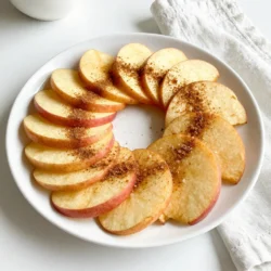 To make crispy cinnamon sugar apple chips, you need: - 2 large apples (preferably Fuji or Honeycrisp) - 2 tablespoons granulated sugar - 1 teaspoon ground cinnamon - 1 tablespoon lemon juice - Pinch of salt These ingredients work together to create a sweet and crunchy snack that you will love. I recommend using Fuji or Honeycrisp apples for this snack. These varieties are crisp and sweet. They hold their shape well while baking and give the best flavor. You can also try Granny Smith apples for a tart twist. You can add more taste to your apple chips with these optional ingredients: - A dash of nutmeg for warmth - A splash of vanilla extract for sweetness - A sprinkle of sea salt for a savory touch Feel free to mix and match these flavors to find your favorite! {{ingredient_image_1}} Start by washing and drying your apples. I suggest using Fuji or Honeycrisp apples. These apples taste sweet and stay crisp. Next, core the apples. You can use a knife or a mandoline slicer. Slice them thinly, about 1/8 inch thick. This thinness helps them bake evenly. Toss the slices with lemon juice. This keeps them from turning brown. In a small bowl, combine the granulated sugar and ground cinnamon. Add a pinch of salt to enhance the flavor. Mix these ingredients well. This cinnamon sugar mixture will add a sweet touch to the apple slices. Preheat your oven to 200°F (93°C). Line a baking sheet with parchment paper. Arrange the apple slices in a single layer on the sheet. Make sure they do not overlap. Sprinkle the cinnamon sugar mixture over the slices. Toss gently to coat them evenly. Bake for 1.5 to 2 hours. Flip the slices halfway through. They are ready when they look crisp and lightly browned. Let them cool completely. This cooling step helps them get even crisper. Store the chips in an airtight container or share them fresh! To get crispy apple chips, slice apples thin. Aim for 1/8 inch thick slices. A mandoline works best for even cuts. Bake them low and slow at 200°F (93°C). This prevents burning and allows moisture to escape. Flip the slices halfway through baking for even crispness. Let them cool completely after baking. They will become crispier as they cool down. To prevent browning, coat apple slices with lemon juice right after slicing. The acid in lemon juice keeps the apples looking fresh and bright. Toss the slices gently in a bowl to ensure even coating. This step is key for presentation and flavor. Serve these chips as a snack or dessert. They pair well with yogurt or nut butter. You can also sprinkle some extra cinnamon sugar on top if you like. For a fun twist, try serving them with ice cream. They make a great topping for salads too. Enjoy these chips fresh or store them for later munching! Pro Tips Choose the Right Apples: Fuji and Honeycrisp apples are ideal for this recipe due to their sweetness and crisp texture. They will provide the best flavor and crunch for your apple chips. Uniform Slicing is Key: Use a mandoline slicer for consistent thickness in your apple slices. This ensures even baking and helps achieve that perfect crispy texture. Monitor Baking Time: Keep an eye on the apple slices as they bake. Ovens can vary, and some slices may crisp up faster than others, so adjust baking time as needed for optimal results. Store for Freshness: To maintain the crispiness of your apple chips, store them in an airtight container. They can last for a week or more if stored properly. {{image_2}} You can easily change the flavor of your apple chips. For a warm spice, add nutmeg to your cinnamon sugar mix. Just a pinch can make a big difference. If you love vanilla, try adding a few drops of vanilla extract to the lemon juice. This adds a sweet aroma and depth to each bite. Feel free to experiment with other spices, like allspice or cardamom, for unique flavors. If you want to reduce sugar, you can try other sweeteners. Stevia or monk fruit can work well. These sweeteners provide the sweetness without the calories. Just remember to adjust the amount based on the product's sweetness level. For a natural option, use honey or maple syrup. You’ll need to mix them with the lemon juice before tossing with the apple slices. These apple chips can fit many diets. For a keto-friendly snack, use a low-carb sweetener like erythritol. This keeps the chips low in carbs. Since the recipe is naturally gluten-free, anyone can enjoy them without worry. If you want to make them vegan, make sure to use plant-based sweeteners. This way, everyone at your table can enjoy these tasty snacks. After making your cinnamon sugar apple chips, let them cool. Store them in an airtight container. This keeps them fresh and crunchy. You can use glass or plastic containers. Avoid moisture, as it makes the chips soft. If you have leftovers, ensure they are completely cool before sealing. Homemade apple chips can last about one to two weeks. They stay best when stored in a cool, dry place. You might find they lose crispness after a few days. Keep checking for any signs of moisture or softness. If they become soft, it's time to crisp them up again. To make your apple chips crispy again, use your oven. Preheat the oven to 200°F (93°C). Lay the chips on a baking sheet. Bake them for about 10 to 15 minutes. Check often to avoid burning. Let them cool again before storage. This method works wonders to restore that crunch! Yes, you can use other fruits. Pears, bananas, and even peaches work great. Slice them thin, like apples. Follow the same steps in the recipe. Keep in mind, baking times may change. Check them often so they do not burn. To make them sugar-free, use a sugar substitute. Options like stevia or monk fruit are great choices. Mix the substitute with cinnamon as usual. This way, you still get that sweet and spicy flavor. Toss the apple slices in the mixture just like before. Cinnamon sugar apple chips can be a healthy snack! Apples are full of fiber and vitamins. Baking them instead of frying cuts down on fat. The sugar adds some calories, but you can adjust it. Enjoy them in moderation for a tasty, guilt-free treat! You learned how to make tasty cinnamon sugar apple chips. We covered the best ingredients and how to prepare and bake them for a crunchy treat. I shared tips to keep your chips crispy and prevent browning. You also saw fun flavor ideas and storage tips to keep them fresh. Now, you can enjoy a delicious snack anytime. Experiment with different apples and flavors to find your favorite. Keep sharing your snacks with friends and family!