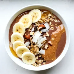 - 2 frozen bananas - 1 cup almond milk or any milk of choice - 2 tablespoons unsweetened cocoa powder - 2 tablespoons natural peanut butter - 1 tablespoon honey or maple syrup (optional) - 1 tablespoon chia seeds The key to a great Chocolate Peanut Butter Smoothie Bowl starts with the right ingredients. Frozen bananas are crucial. They add a creamy texture and natural sweetness. Use almond milk or any milk you like. It helps blend the ingredients smoothly. Unsweetened cocoa powder brings out the rich chocolate flavor. Natural peanut butter adds depth and creaminess without extra sugar. You can sweeten it with honey or maple syrup, depending on your taste. Chia seeds are a fantastic addition. They boost nutrition and add fiber. They also help thicken the smoothie. - Sliced banana - Chopped nuts - Granola - Coconut flakes - Honey drizzle Toppings make your smoothie bowl fun and tasty. Sliced bananas add freshness and color. Chopped nuts give a nice crunch. Granola adds texture and can help keep you full. Coconut flakes bring a tropical vibe, while a honey drizzle adds sweetness. Arranging these toppings can turn your smoothie bowl into a work of art! {{ingredient_image_1}} - In a blender, combine: - 2 frozen bananas - 1 cup almond milk - 2 tablespoons unsweetened cocoa powder - 2 tablespoons natural peanut butter - 1 tablespoon honey or maple syrup (optional) Blend these ingredients until smooth and creamy. If you want a thicker or thinner texture, adjust the almond milk. You can add a little more milk if it feels too thick or less if you want it creamier. Next, mix in 1 tablespoon of chia seeds. Pulse the blender a few times to combine. This helps keep the smoothie texture while adding nutrients. Now, pour the mixture into a bowl. For the fun part, arrange your toppings! You can use sliced banana, chopped nuts, granola, or coconut flakes. Be creative with your designs. Try to make patterns to make it look nice. A drizzle of honey on top adds sweetness and a pretty finish. To make your bowl pop, serve it with colorful toppings. The bright colors will stand out against the dark chocolate base. You can even sprinkle a bit of cocoa powder around the edges for extra flair. Aim for a serving size that feels satisfying but not too heavy. This smoothie bowl is great for breakfast or a snack, and it serves two. Enjoy this tasty, nourishing delight! You can swap out sweeteners based on your taste. Try maple syrup or agave for a unique touch. If you want to make it dairy-free, almond milk works great. Other options include oat milk or coconut milk. A high-speed blender is best for a smooth consistency. Brands like Vitamix or Ninja excel in blending frozen fruits. If your blender struggles, add more almond milk to help it blend smoothly. Arranging toppings can be fun! Try to create patterns with sliced bananas and nuts. You can also sprinkle coconut flakes or granola for added texture. A drizzle of honey on top adds sweetness and looks pretty. Pro Tips Use Ripe Bananas: The riper the bananas, the sweeter and creamier your smoothie bowl will be. Look for bananas with brown spots for maximum flavor. Customize Your Milk: Feel free to swap almond milk for coconut milk, oat milk, or any milk of your choice to enhance the flavor profile of your smoothie bowl. Experiment with Toppings: Get creative with your toppings! Try adding seeds, berries, or even a dollop of yogurt for a unique twist on your smoothie bowl. Chill Your Bowl: For a refreshing experience, chill your serving bowl in the freezer for a few minutes before adding the smoothie mixture. {{image_2}} You can make your chocolate peanut butter smoothie bowl even better. Adding vanilla extract gives it a warm, sweet flavor. Just a teaspoon can change everything! You might also try other nut butters. Almond or cashew butter can add unique tastes. These swaps can keep your bowl fresh and fun. Want to make your smoothie bowl healthier? Try adding protein powder. It helps keep you full and adds extra nutrition. You can also boost your bowl with greens. Spinach or kale blends in well without changing the taste. This way, you get more vitamins and minerals with every bite. Change up your toppings based on the season. In summer, add fresh berries for a fruity twist. In winter, try diced apples or pears for a cozy touch. You can also have fun with themed toppings. Use red and green fruits for the holidays. Let your smoothie bowl reflect the season or special events! To store leftovers in the fridge, pour any extra smoothie into an airtight container. Seal it well to keep it fresh. It can last for up to two days in the fridge. When you are ready to eat, give it a good stir. You might need to add a splash of milk to thin it out. For long-term storage, you can freeze prepared smoothie bowls. Use a freezer-safe container or a silicone mold for easy removal. Leave some space at the top, as the smoothie will expand when frozen. When you want to enjoy it, thaw in the fridge overnight. You can also set it out on the counter for about an hour. Avoid using a microwave, as it can change the texture. The ingredients in your smoothie bowl have different shelf lives. Frozen bananas can last up to six months in the freezer. Almond milk stays good for about a week in the fridge after opening. Chia seeds can last for a year if stored in a cool, dry place. Once you assemble your smoothie bowl, eat it within two days for the best taste and texture. Yes, you can use fresh bananas. However, frozen bananas make the smoothie thicker and creamier. They also chill the drink without needing ice. This gives you a smooth and rich texture. Fresh bananas work but may result in a thinner consistency. You can use any milk you like. Options include soy milk, oat milk, or coconut milk. For nut-free diets, try rice milk or hemp milk. Each milk adds its own taste and creaminess. Choose one that fits your taste and dietary needs. Yes, this smoothie bowl works well for meal prep. You can make it ahead for busy days. Prepare the base and store it in the fridge for up to two days. When ready to eat, add your favorite toppings. This keeps them fresh and crunchy. This blog post covered how to make a delicious smoothie bowl. We started with the main ingredients like frozen bananas and almond milk. Then, I shared simple steps to blend and serve your bowl. You also learned tips for presentation and ingredient swaps. Smoothie bowls are versatile. They can fit your taste and diet. Enjoy trying different fruits and toppings! With these tips, you can create a bowl everyone will love. Dive into your smoothie bowl journey and make it a fun, tasty experience!